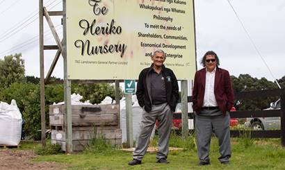 Two men standing in front of a sign for Te Heriko Nursery.