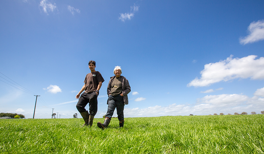 2 people walking through a field.