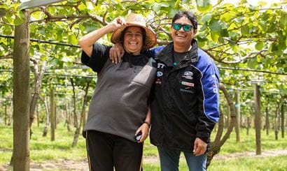 Two women laughing together at an orchard.