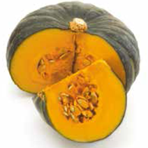 A green buttercup squash with a quarter cut out and lying on the bench, showing the seeds and bright orange inside.
