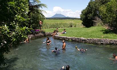 A group of people swimming and playing in a river.
